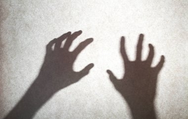 Ürkütücü ruha yardım et, eller ve parmaklar, ve tekstil perdesinin arkasında bulanık vücut silueti.