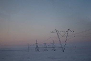 Yüksek gerilim hatları çöl bölgelerinden geçiyor, uzun mesafeler boyunca enerji iletiyor..