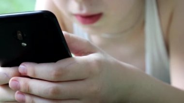 Çocuk yatakta yatıyor ve bir akıllı telefondan cevap veriyor..
