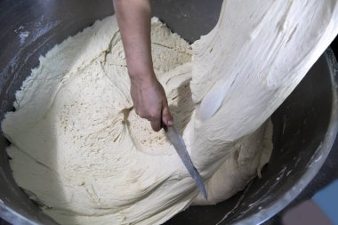 Yoğurulmuş hamur ekmeğe konmak için kesilir..