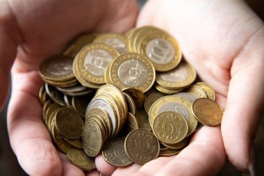Kadınların elleri 100 tenge değerindeki madeni paraları tutar, asgari geçim sağlar..