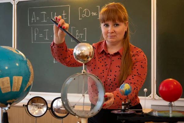 A physics teacher conducts an experiment with an Electrometer.