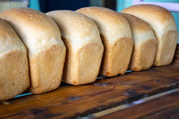 갓 구운 빵을 빵집의 쟁반에 넣는다. — 스톡 사진