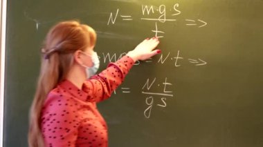 Matematik öğretmeni dersi tahtaya yakın öğrencilere açıklar..