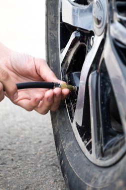 Adam hava basıncı ve dolum havada araba lastikleri kontrol etmek. Kavram resmi