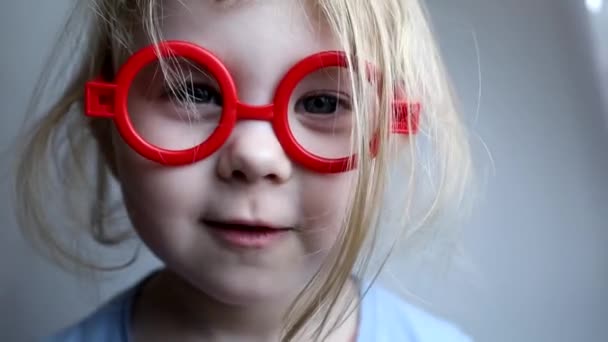 赤いおもちゃの眼鏡で波状の髪の女の子. — ストック動画