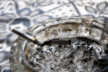 Sigara ve sigara izmaritleri cam kül tablasında. Yüksek kalite fotoğraf