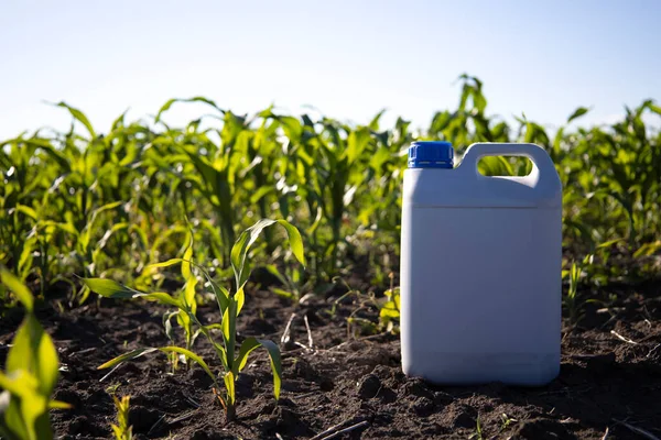 Herbicide plastic canister can in corn field, crop protection concept. High quality photo
