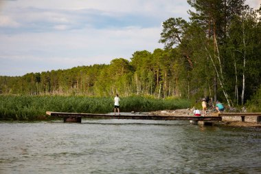 The boy on the pier is fishing. Summer vacation of the child. High quality photo