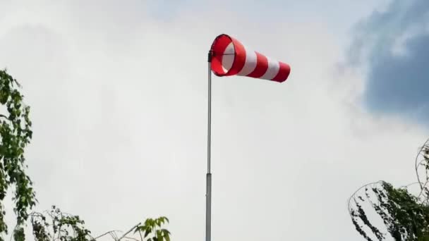 Větrná ponožka, červený a bílý ukazatel ukazující sílu a směr větru proti obloze. — Stock video