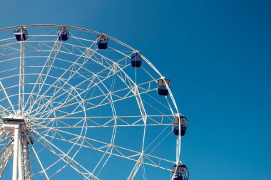 Güneşli bir günde mavi gökyüzüne karşı dönme dolap..