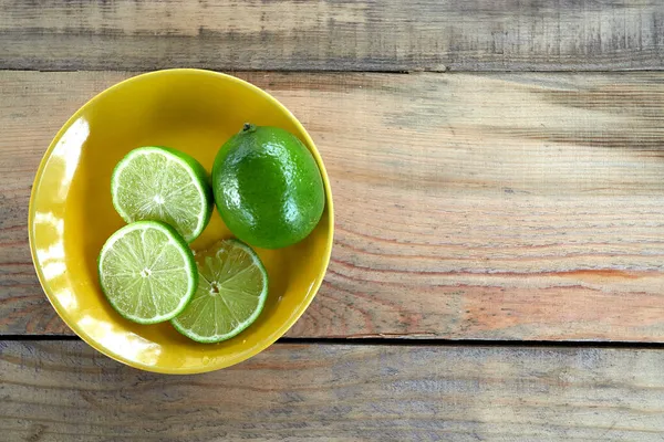 Tahta masada yeşil yapraklı doğal taze kireç..
