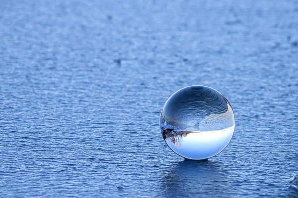Хрустальный шар лежит на льду озера. — стоковое фото