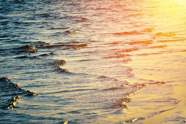 Superfície de água com ondas pequenas. Rio, lago, lago. Raios dourados de sol refletidos na superfície da água. — Fotografia de Stock