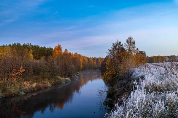 Herbstlicher Sonnenaufgang mit Bäumen und Fluss. Morgenlandschaft mit trockenem Gras. — Stockfoto