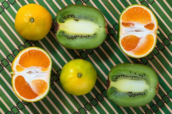 Turunçgil arkaplanlı portakal renkli kivi. Düztaban kompozisyonu. Üst görünüm.