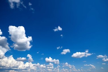 Güneşli bir günde mavi gökyüzünde beyaz bulutlar.