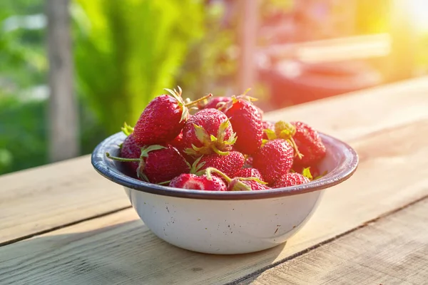 Fresas frescas y jugosas en un tazón de metal viejo sobre un fondo de madera. — Foto de Stock