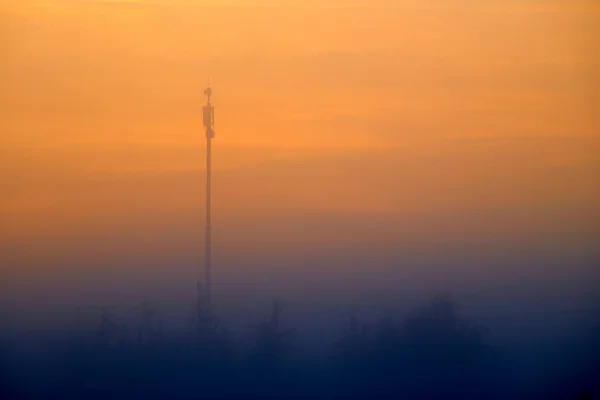 Wieża komórkowa wcześnie rano we mgle. — Zdjęcie stockowe