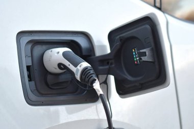 Elektrikle şarj edilen beyaz bir elektrikli arabanın yakınlaştırılması