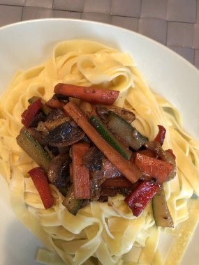 Akşam yemeği, makarna ve bir tabakta kızarmış sebze.