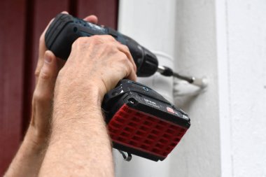 Evi geliştirmek için tornavida kullanan bir adam.