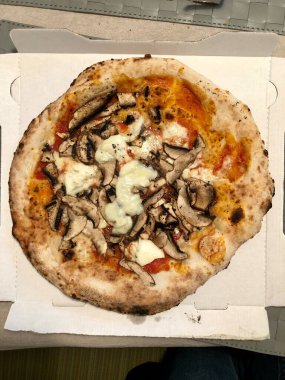 Taş fırında yapılan bir restorandan alınmış pizzanın tepeden çekilmiş fotoğrafı.