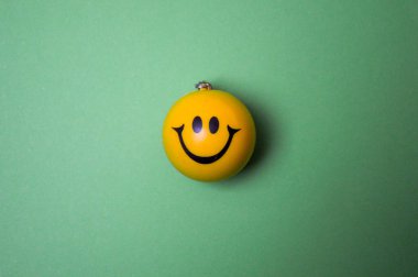 Photo of a yellow smiley face on green background
