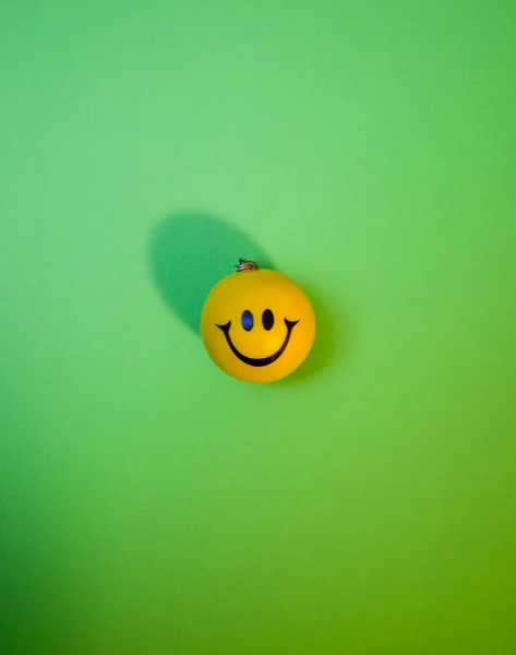 Photo of a yellow smiley face on green background