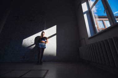 Mükemmel vücut ve karın kasları olan genç bir bayan sporcu sabahın erken saatlerinde antrenmana hazırlanıyor.