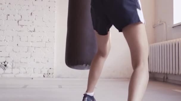 Mooie kickboxing vrouw training bokszak in fitness studio. — Stockvideo