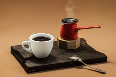 Creative coffee background for cafe. Cup with coffee and cezve with on a wooden board. Copy space.