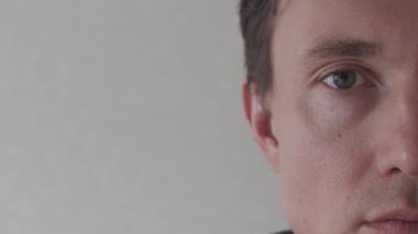 Genç Adam 'ın Yarım Yüzü Kameraya Bakıyor. İnsan vücudu anatomisi ve iş konsepti videosu