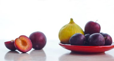                             red plums and yellow figs on a white background   