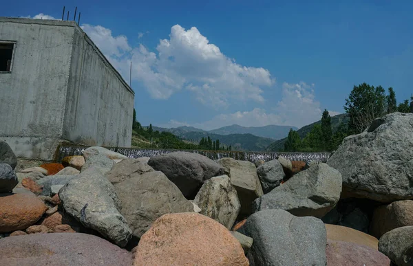 Mountains and blue sky can be seen behind the big rocks