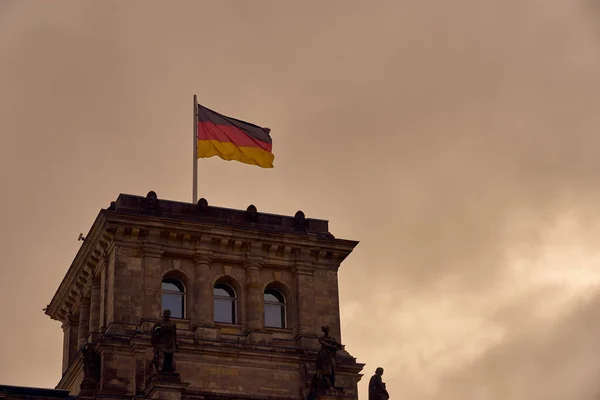 Deutschland-Fahne vor dem Hintergrund eines bewölkten Himmels. — Stockfoto