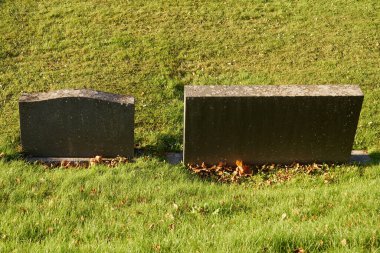 Granit mezar taşları ve mezarlıkta yeşil bir çimen.