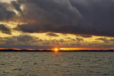 Baltık Denizi 'nde renkli bir günbatımı. Ufukta güneşin batışı ile aydınlanan bulutlar..