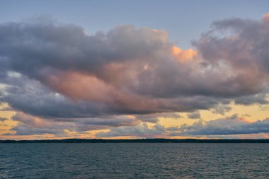 Baltık Denizi 'nde renkli bir günbatımı. Ufukta güneşin batışı ile aydınlanan bulutlar..