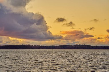 Baltık Denizi 'nde renkli bir günbatımı. Ufukta güneşin batışı ile aydınlanan bulutlar..