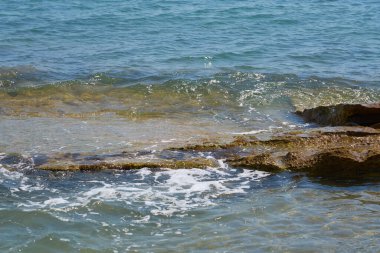 Girit 'in taştan kıyılarında dalgalar.