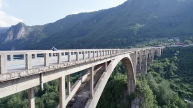Bir dağ zirvesinin altındaki buzul gölü havadan çekilen yeşil kozalaklı ağaçlarla çevrilidir. Suyun hemen üstünde ve kıyı boyunca gölün büyüklüğünü ve gölün çevresini en az renk düzeltmesi ile gözler önüne serer.