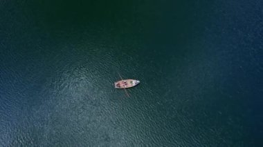 Bir dağ zirvesinin altındaki buzul gölü havadan çekilen yeşil kozalaklı ağaçlarla çevrilidir. Suyun hemen üstünde ve kıyı boyunca gölün büyüklüğünü ve gölün çevresini en az renk düzeltmesi ile gözler önüne serer.
