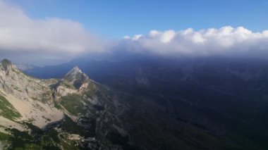Şafak vakti dağ zirveleri Durmitor 'un tepelerinin ardında yükselen güneşin yönüne doğru yükselen bir hava aracı tarafından yakalanır.