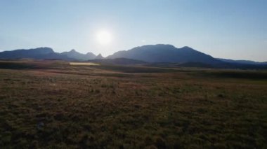Durmitor dağlarına doğru dalgalı çayırların üzerinden günbatımına doğru uçarken
