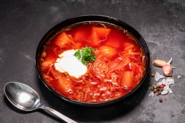 Borsch. Ukrayna çorbası. Kırmızı çorba. Ekşi kremalı ve soğanlı Borsch, beyaz ekmek. Ekşi kremalı geleneksel Rus çorbası. Siyah arka planda ekşi kremalı lezzetli yemek kavramı.