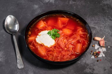 Borsch. Ukrayna çorbası. Kırmızı çorba. Ekşi kremalı ve soğanlı Borsch, beyaz ekmek. Ekşi kremalı geleneksel Rus çorbası. Siyah arka planda ekşi kremalı lezzetli yemek kavramı.