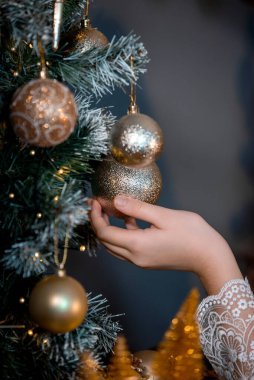 Noel ağacı süsleme süreci. Noel ağacını Noel ağacı arka planıyla süslüyor ve Noel süslerini karla, kıvılcımla, ışıltıyla süslüyor. Mutlu yıllar ve Xmas teması