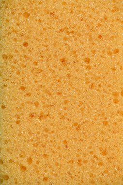 Sünger dokusu arka planı. Sarı sünger dokusu detayı, sünger dokusu arka planı. Sarı süngerin ayrıntılı dokusu. Sünger arkaplan dokusu.
