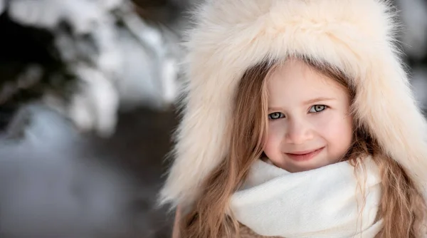 Πορτρέτο του χαρούμενου χαρούμενου χαρούμενου μικρού κοριτσιού, χαριτωμένο παιδί. Όμορφο παιδί περπατά στο πάρκο το χειμώνα σε χιονισμένη μέρα στη φύση σε γούνινο καπέλο, κοντά με copyspace. οικογενειακές διακοπές, έννοια της μόδας — Φωτογραφία Αρχείου